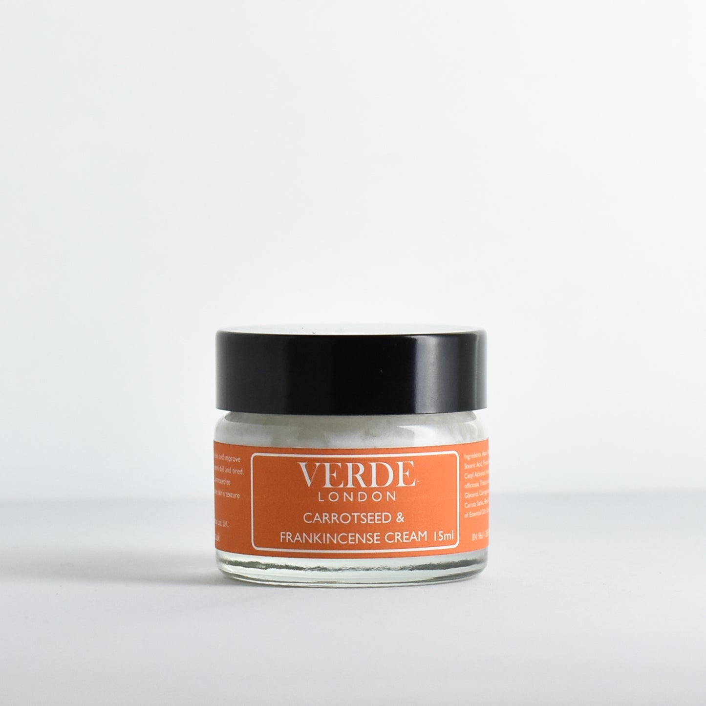 Glass jar of Carrotseed and Frankincense cream with an orange label by the brand Verde London on a white background