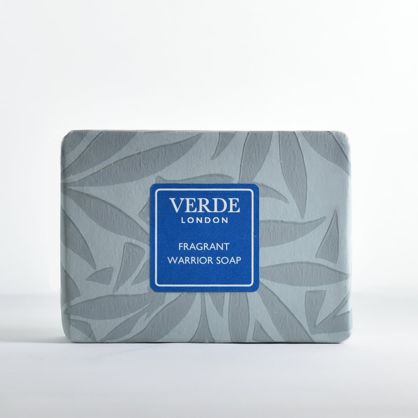 Bar of soap 'Fragrant Warrior Soap' wrapped in patterned paper with a turquoise label from the brand Verde London on a white background