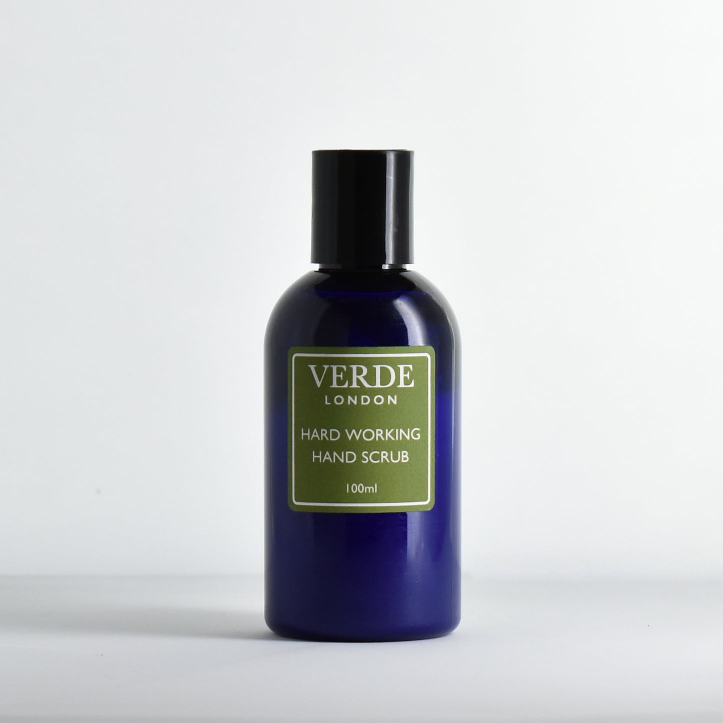 Blue bottle of Verde London hard working hand scrub with a green label on a white background