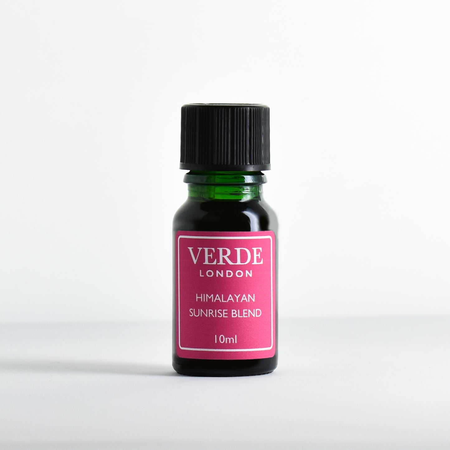 Green glass dropper bottle with pink label containing 'Himalayan Sunrise Blend' by Verde London on a white background.