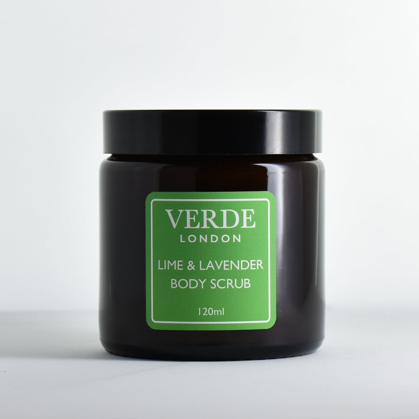 Glass jar of Lime & Lavender Body Scrub by Verde London with a green label on a white background