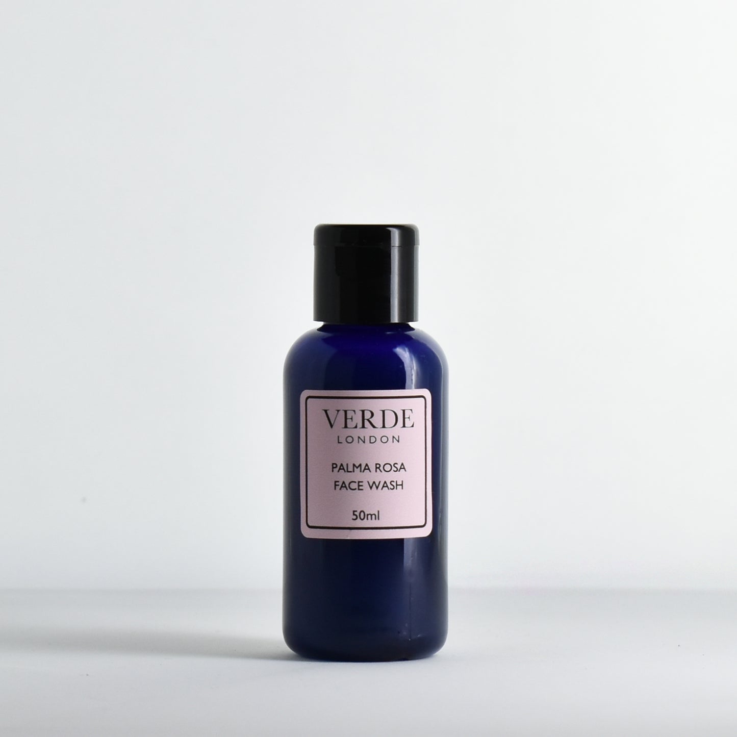 Blue bottle of Palma Rosa Face Wash by Verde London with a pink label on a white background