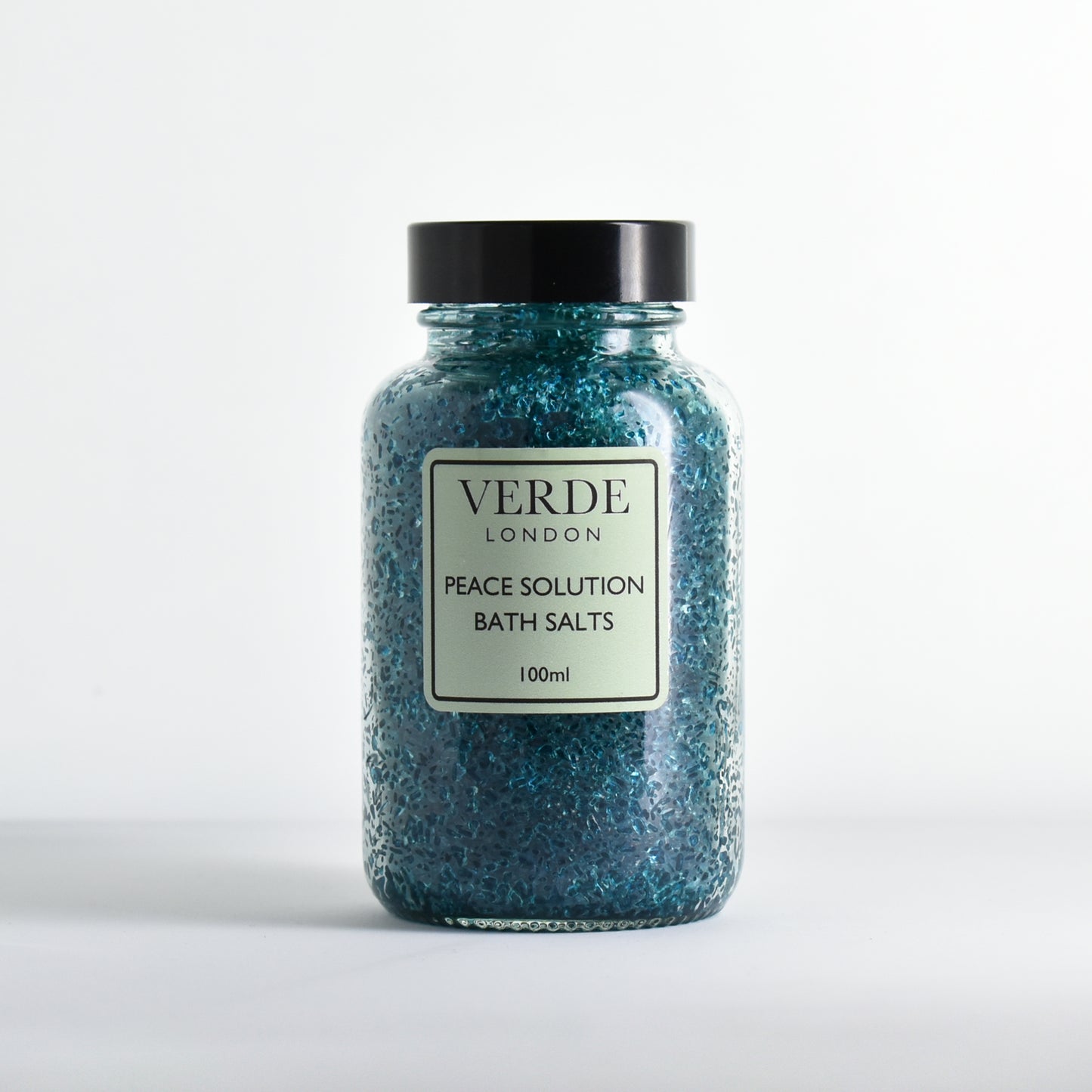 Glass jar of Verde London green Peace Solution Bath Salts on a white background