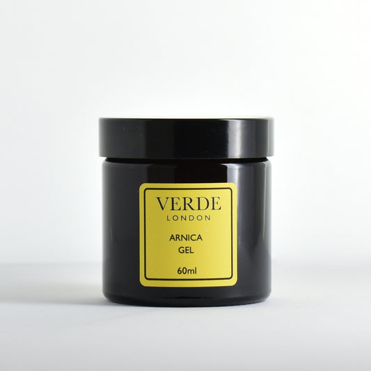 Amber glass jar of Arnica Gel by the brand Verde London with yellow label on a white background
