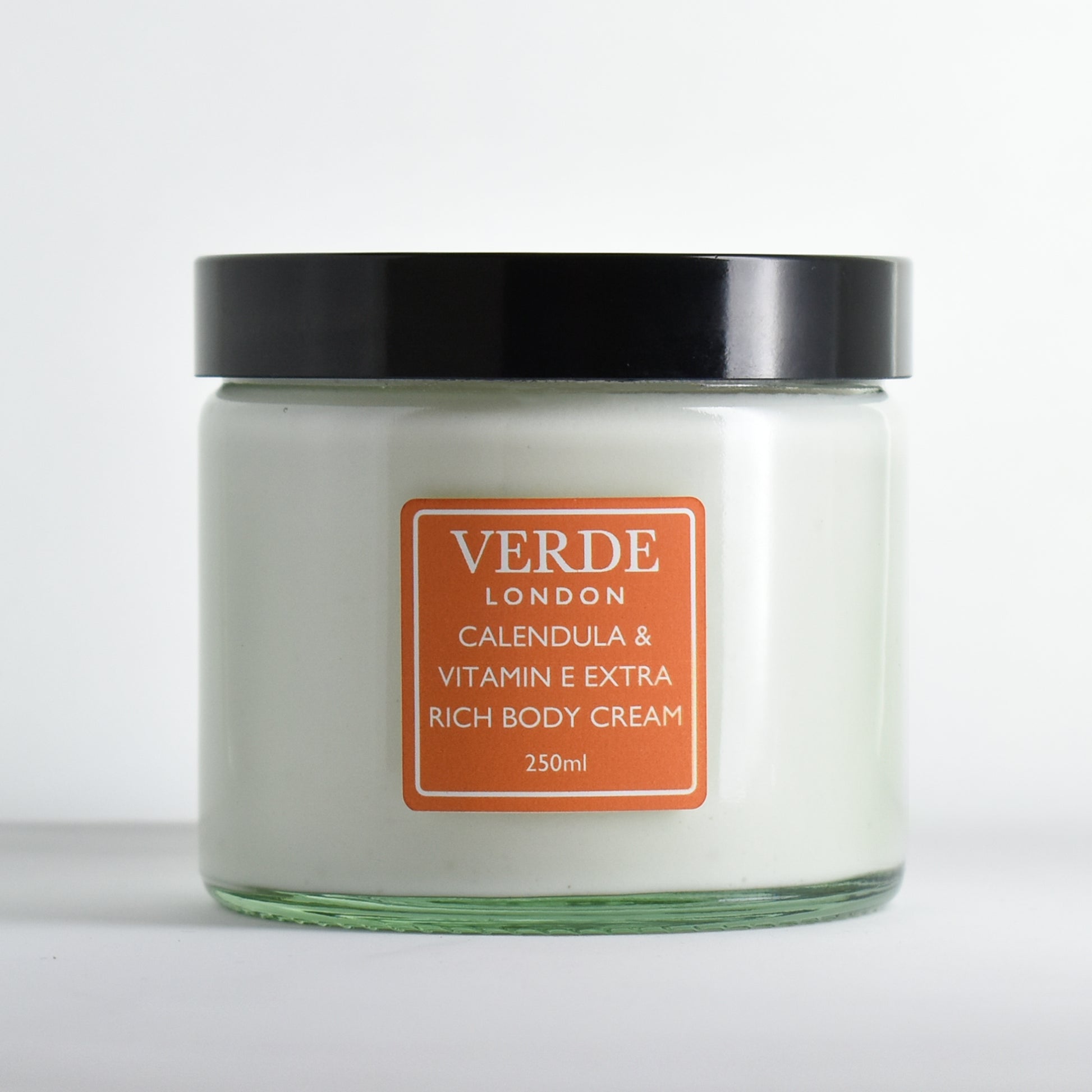 Glass jar of Verde London 'Calendula and Vitamin E eXtra Rich Body Cream' with an orange label on a white background