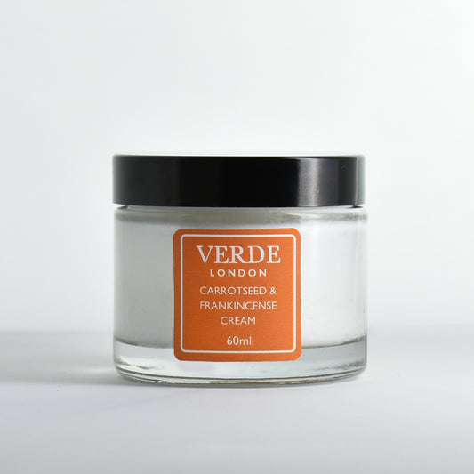 Glass jar of Carrotseed and Frankincense cream with an orange label by the brand Verde London on a white background