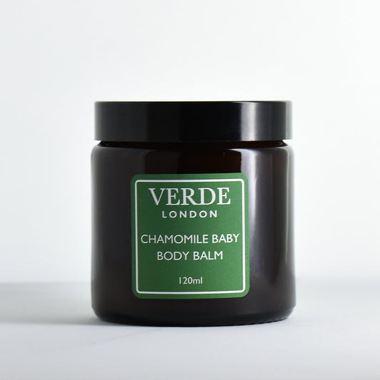 Amber glass jar of Chamomile Baby Body Balm by Verde London with a green label on a white background