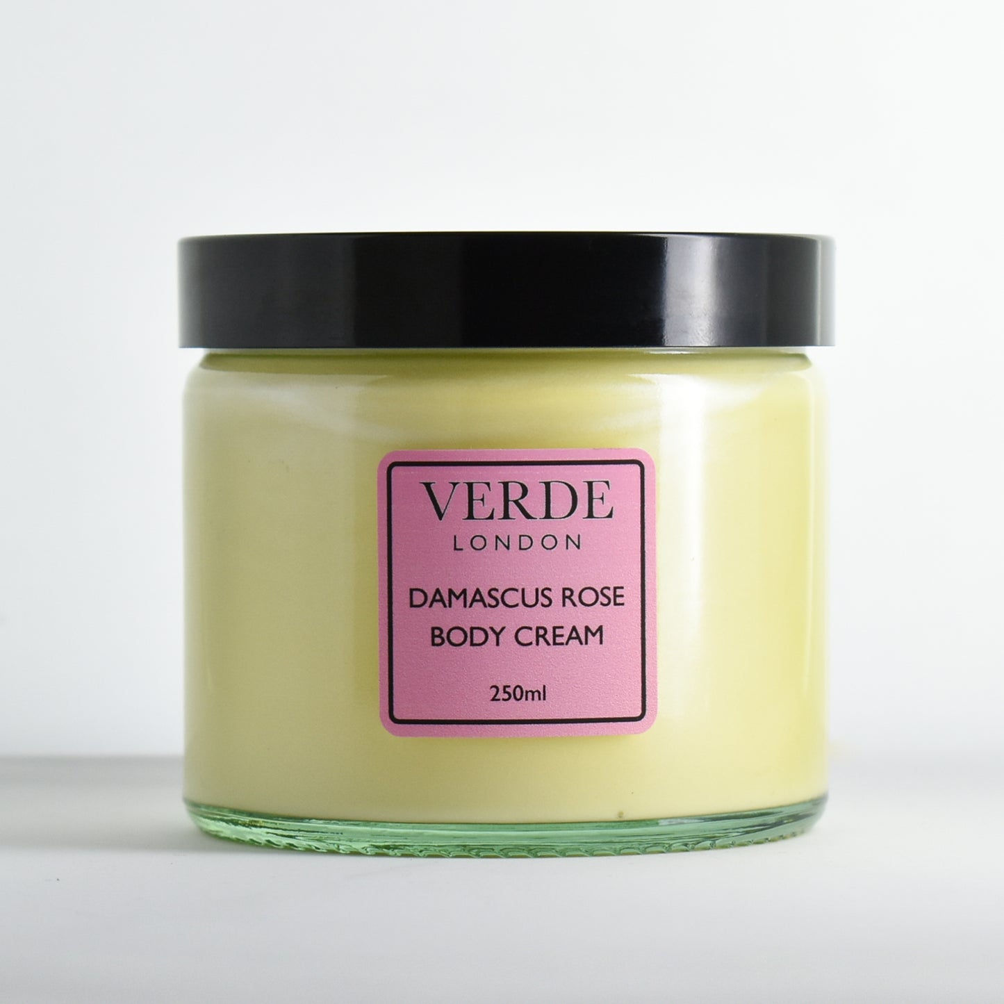 Glass jar of Damascus Rose Body Cream by Verde London with a pink label on a white background
