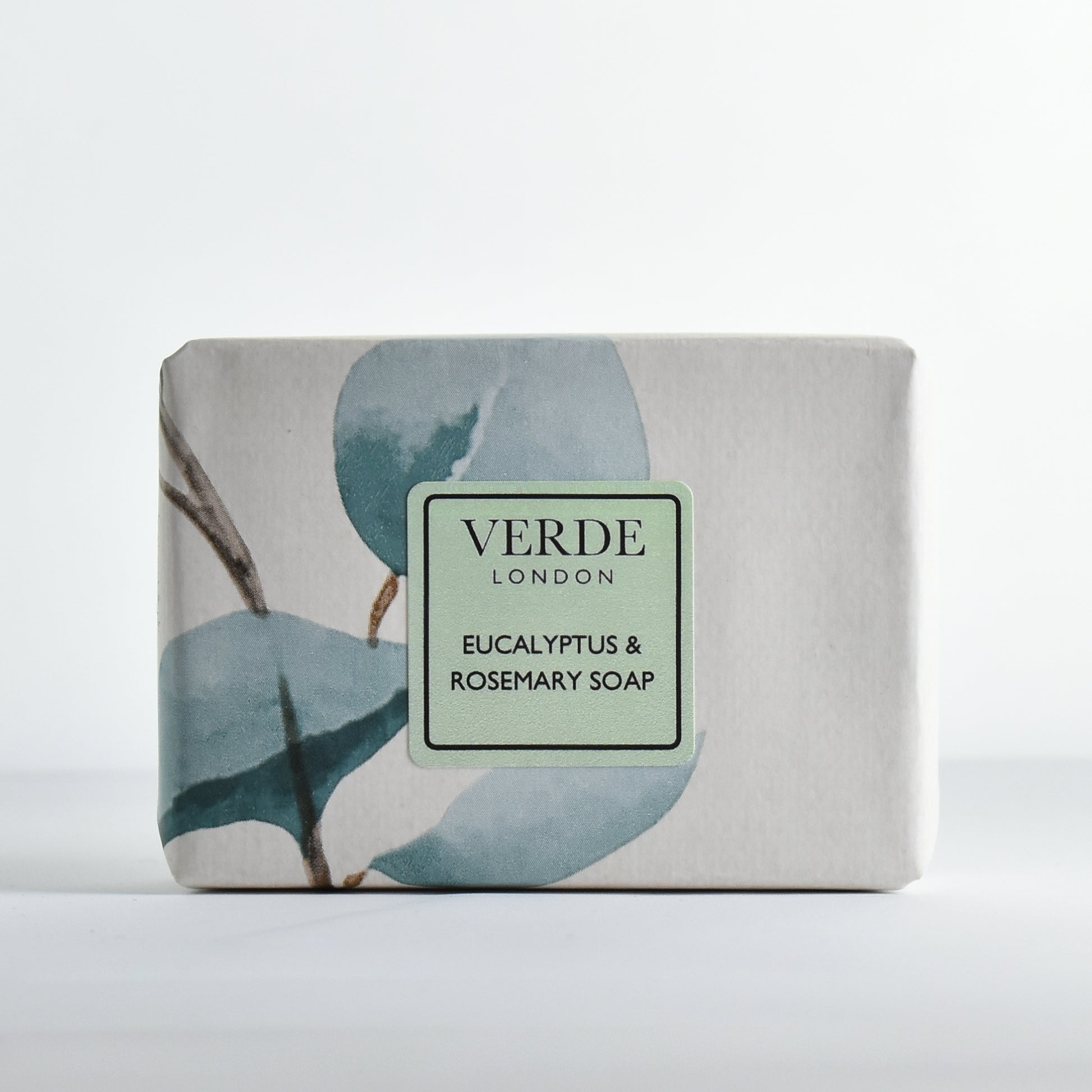 Bar of Eucalyptus & Rosemary soap wrapped in colourful paper with a pale green 'Verde London' label on a white background