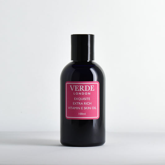 Blue 100ml bottle of Exquisite Exra Rich Vitamin E Skin Oil by the brand Verde London with a pink label on a white background