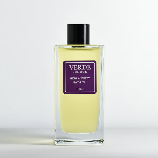 Bottle of 100ml 'High Anxiety Bath Oil' with a dark purple label by Verde London in a rectangular glass bottle on a white background