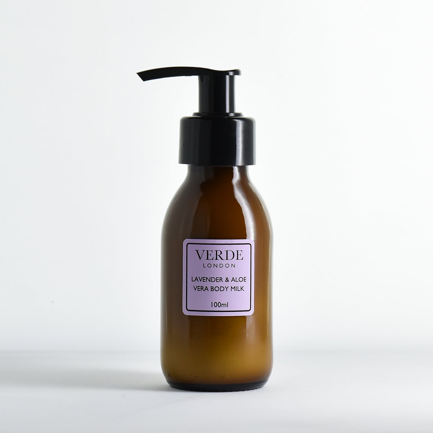 Amber bottle of Verde London Lavender & Aloe Vera Body Milk with a pump and purple label on a white background