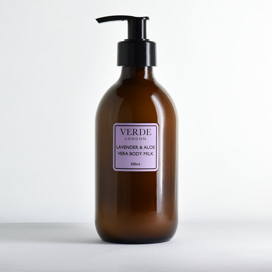 Amber bottle of Verde London Lavender & Aloe Vera Body Milk with a pump and purple label on a white background