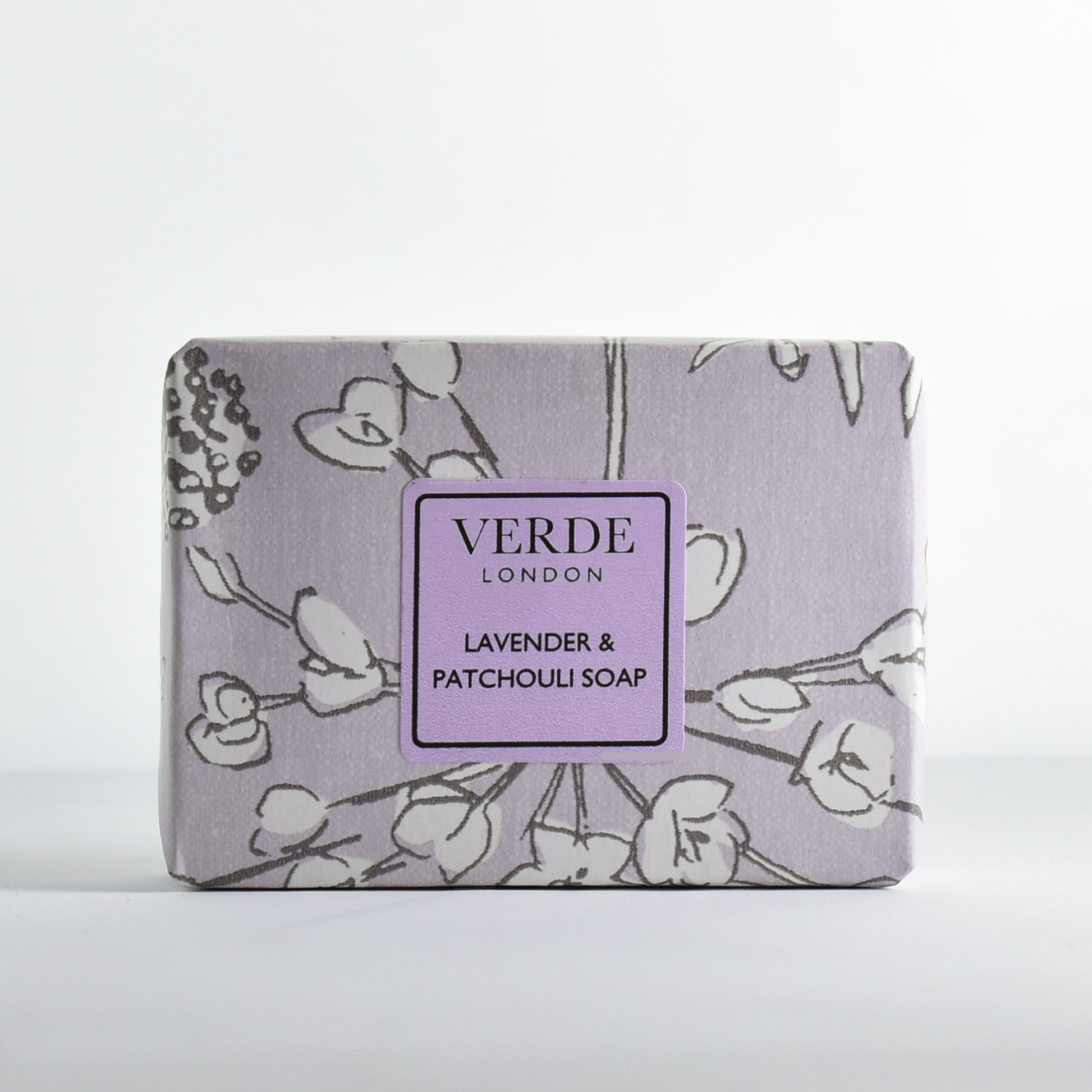 Lavender & Patchouli Soap Bar by Verde London wrapped in purple flower patterned paper with a purple label on a white background