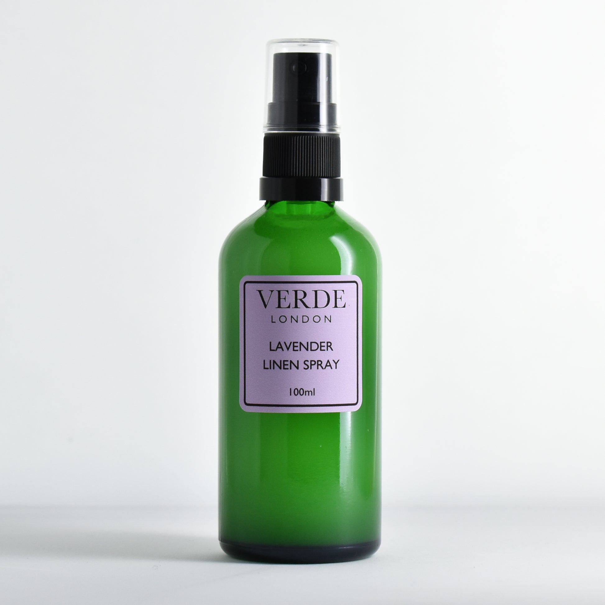 Green bottle of Verde London Lavender Linen Spray with a purple label on a white background