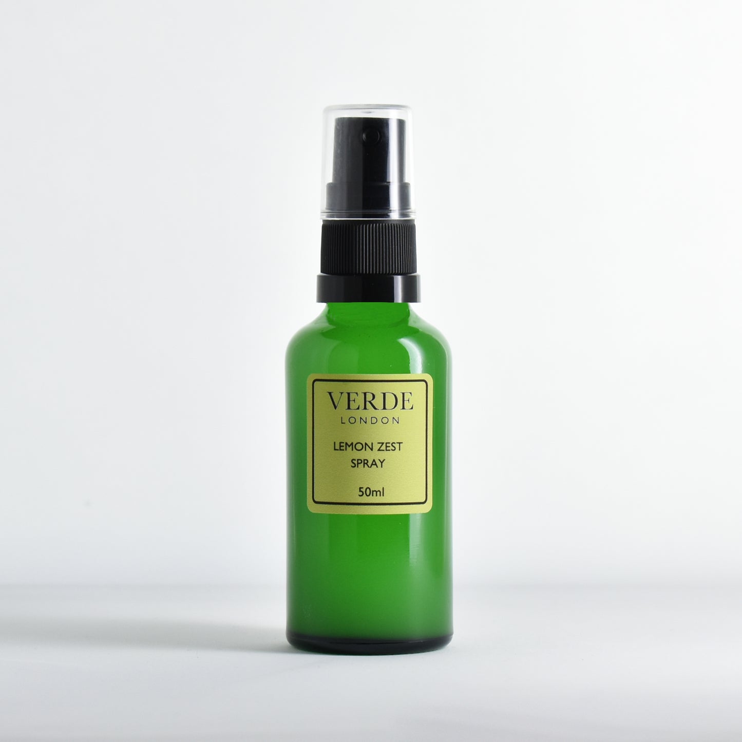 Green glass spray bottle of Verde London Lemon Zest spray with a pale green label on a white background