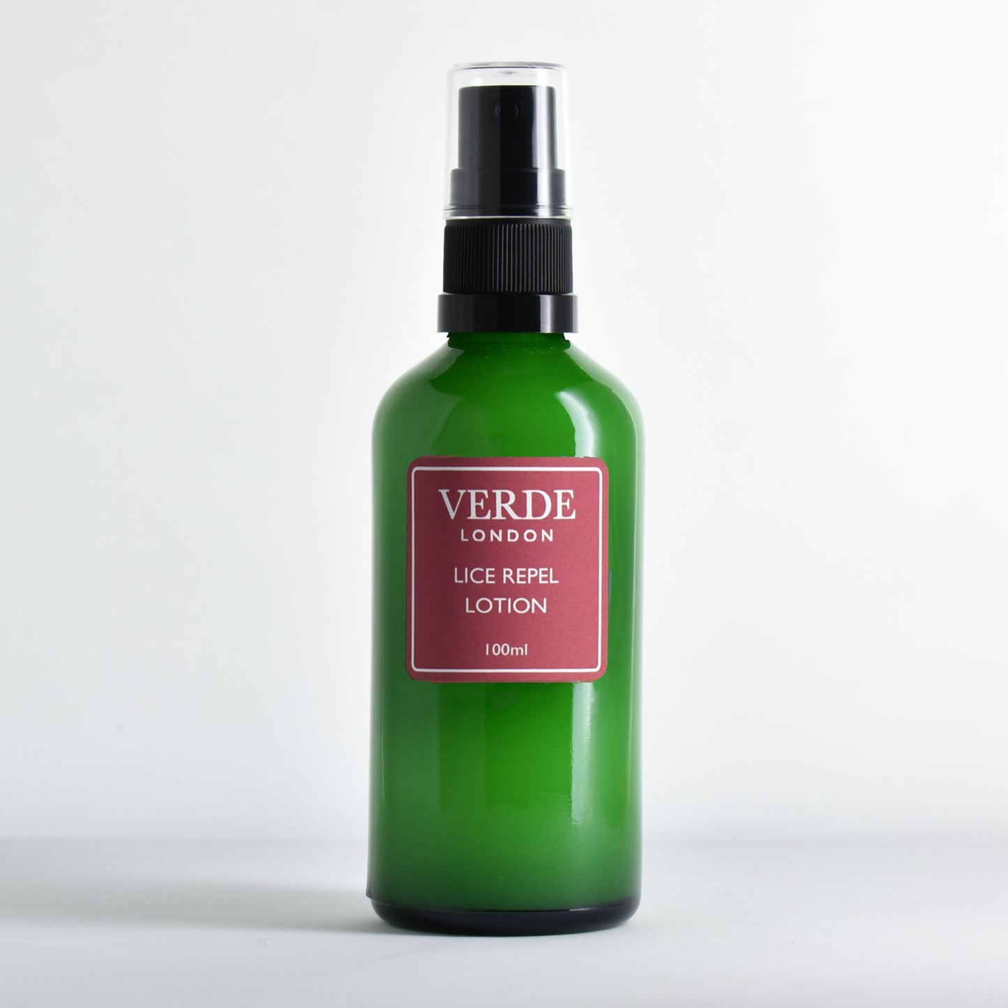 Green glass spray bottle of 'Lice Repel Lotion' by the brand Verde London with a red label on a white background