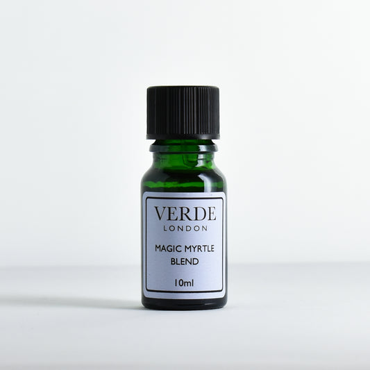 Green glass bottle of 'Magic Myrtle Blend' by Verde London with a pale blue label on a light gray background