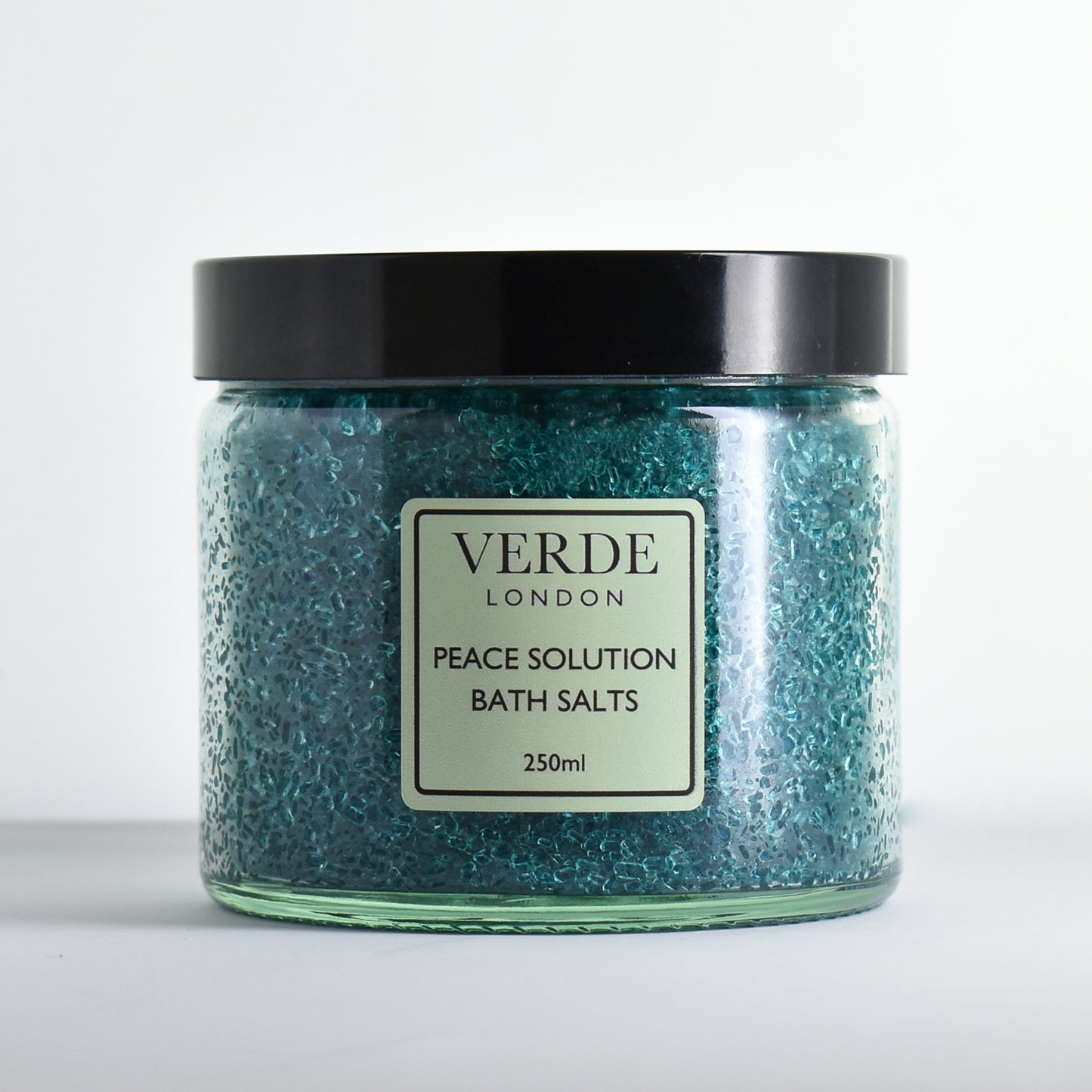 Glass jar of Verde London green Peace Solution Bath Salts on a white background
