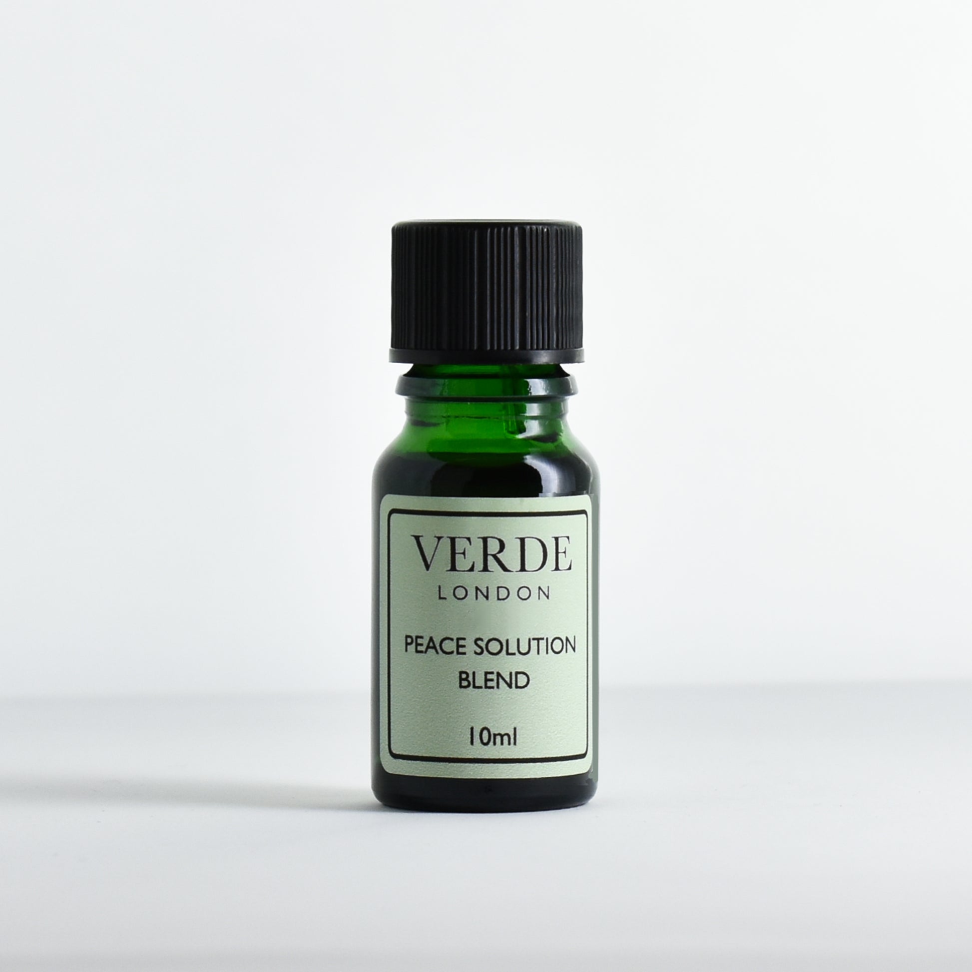 Green glass dropper bottle with pale green label containing 'Peace Solution Blend' by Verde London on a white background.