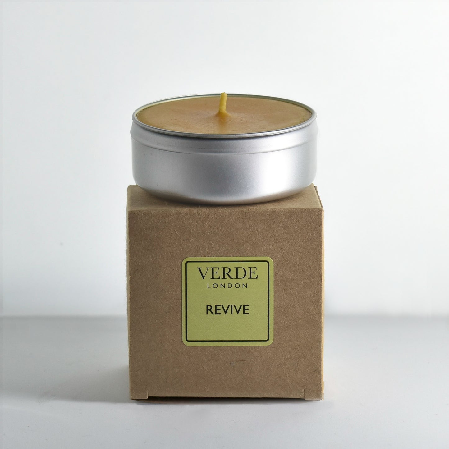 Revive Candle in a metal tin on a cardboard box with 'Verde London' branding