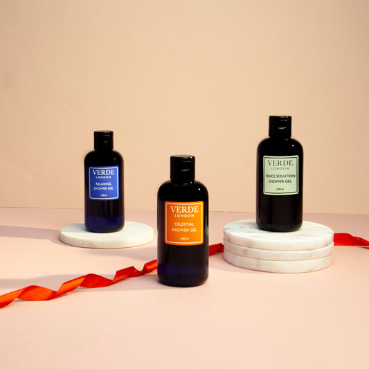 Three bottles of shower gel on white round bases with a label reading 'VERDE' and different scents indicated such as 'Celestial', 'Peace Solution', and 'Relaxing'.