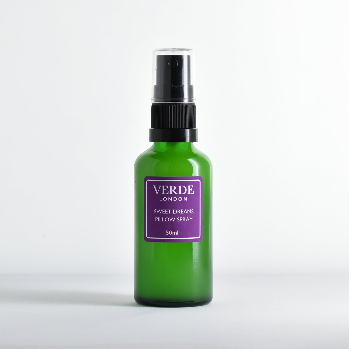 Green glass bottle of 'Verde London' Sweet Dreams Pillow Spray with purple label on a white background
