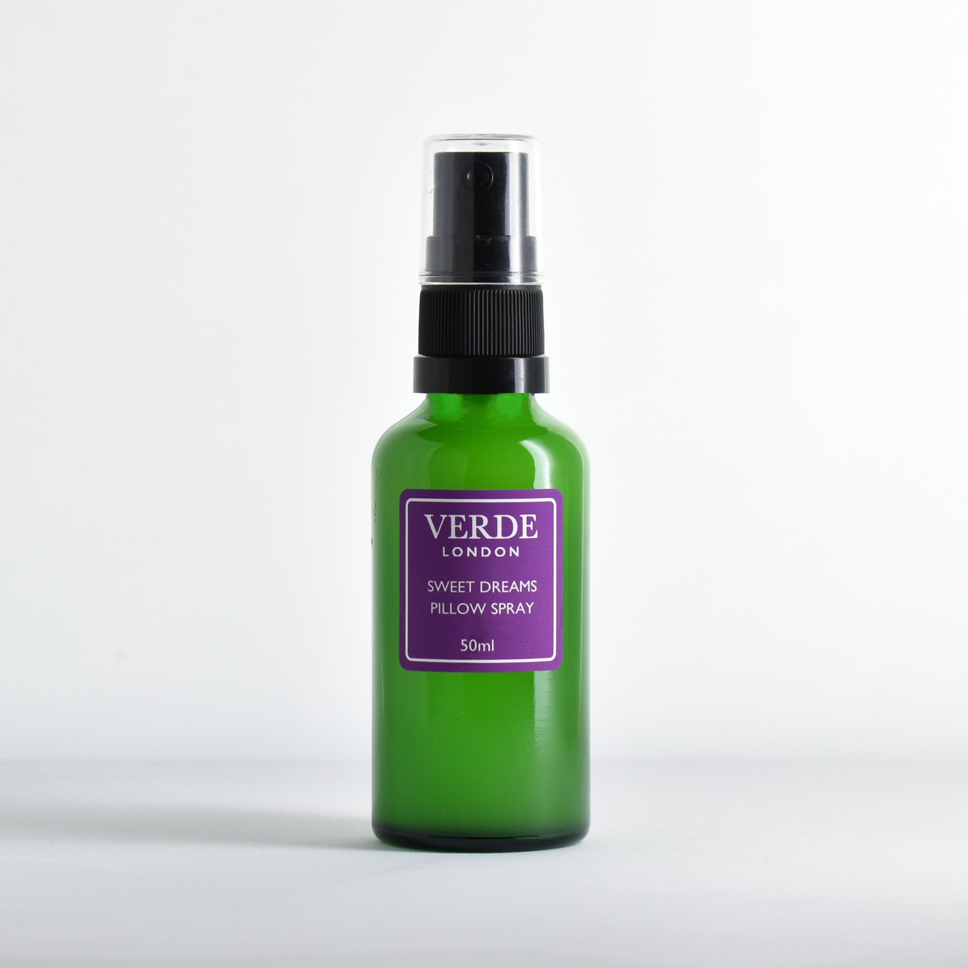 Green glass bottle of 'Verde London' Sweet Dreams Pillow Spray with purple label on a white background