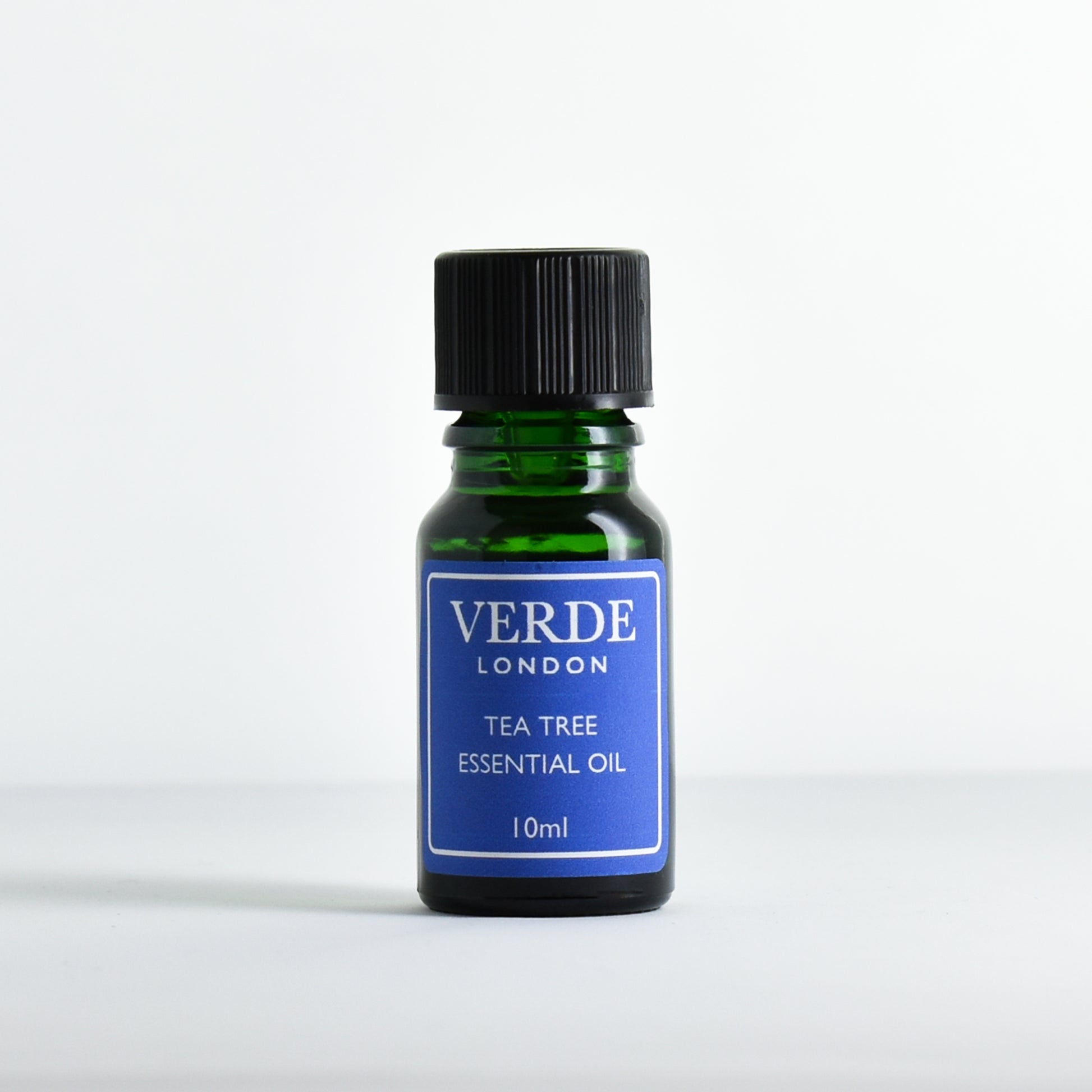 Green glass dropper bottle containing 'Tea Tree Essential Oil' by Verde London on a white background.