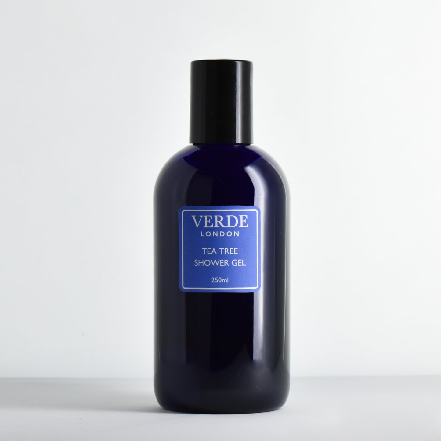 Blue bottle of Verde London Tea Tree Shower Gel with a blue label on a white background