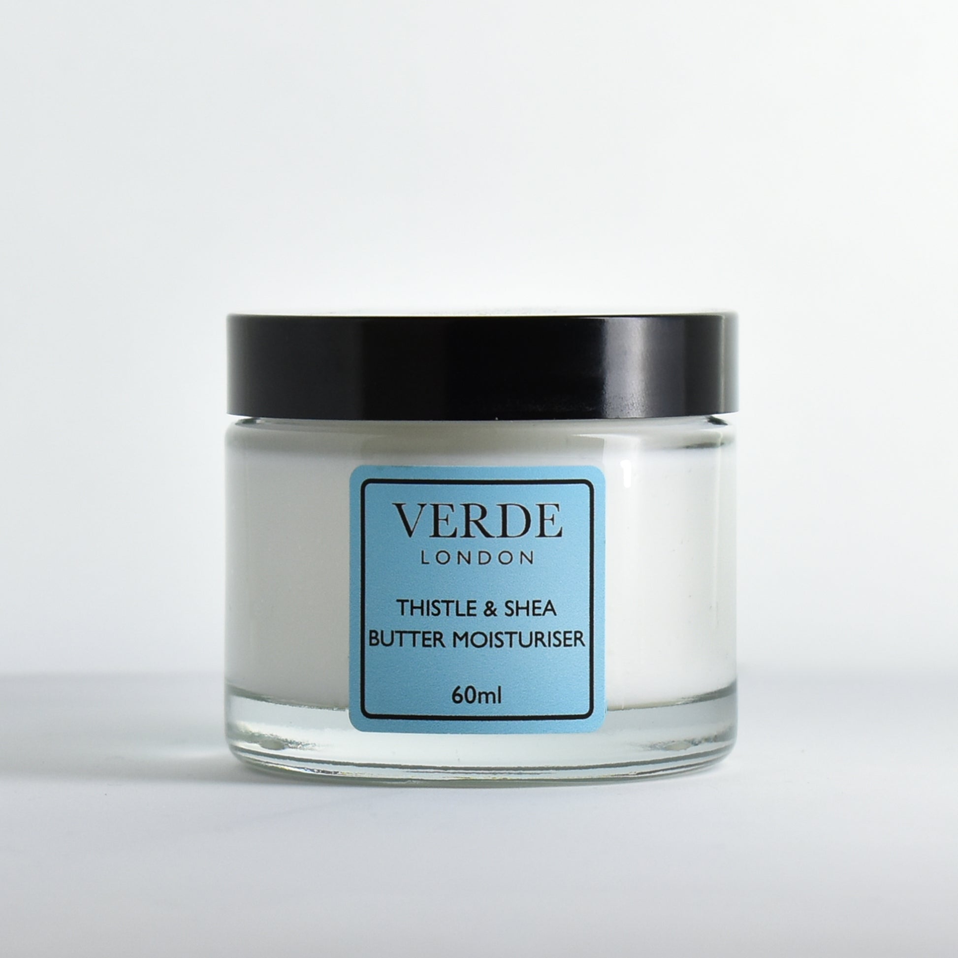 Glass jar of Verde London Thistle and Shea Butter Moisturiser with a blue label on a white background