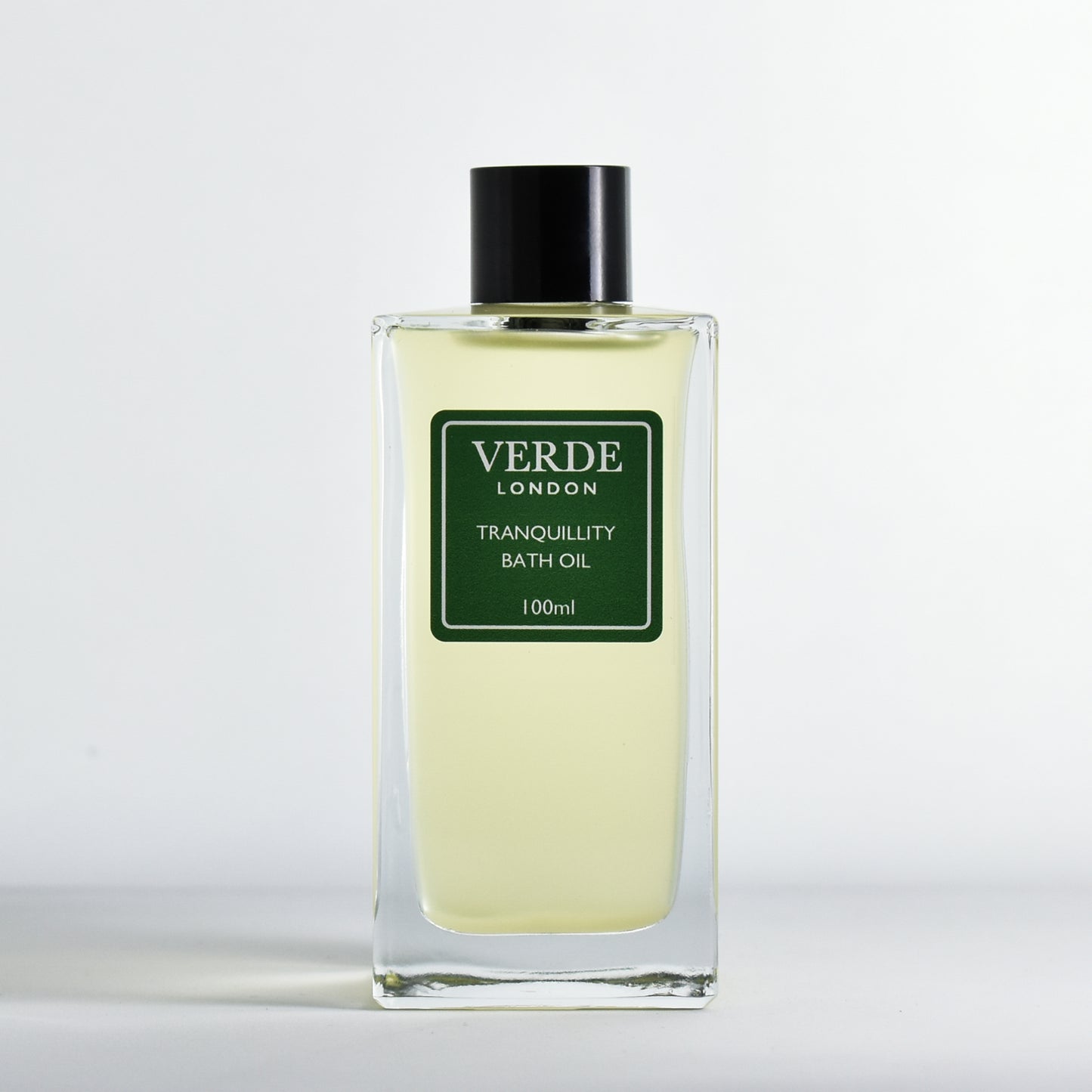 Bottle of Tranquillity Bath Oil by Verde London in a rectangular clear glass bottle with a green label on a white background
